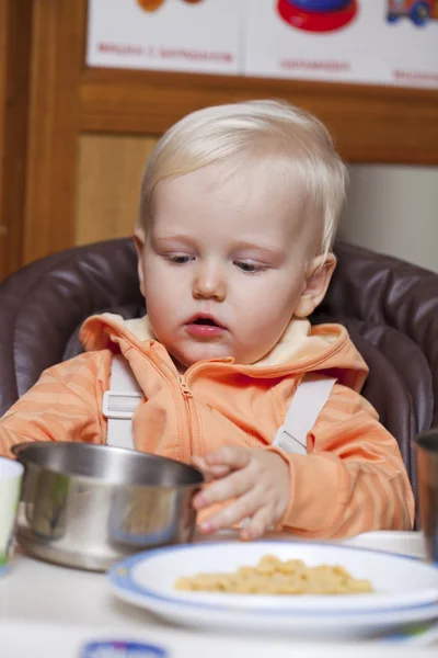Dva roky chlapeček sedí u jídelního stolu — Stock fotografie