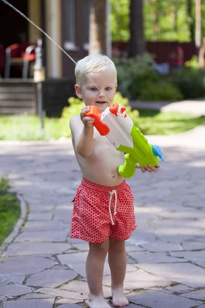 Portrait of blonde baby boy playing with water toy — Stock Photo, Image