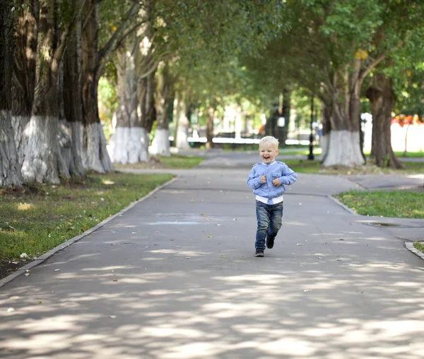 Little boy running on the sidewalk in the summer park — Stock Photo, Image