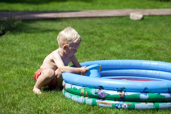 Küçük çocuk çocuk havuzu la üzerinde yakın su ile oynarken — Stok fotoğraf