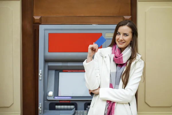 Молодая счастливая брюнетка женщина снимает деньги с кредитной карты в — стоковое фото