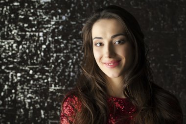 Karanlık stüdyo duvar arka plan üzerinde genç esmer kadın