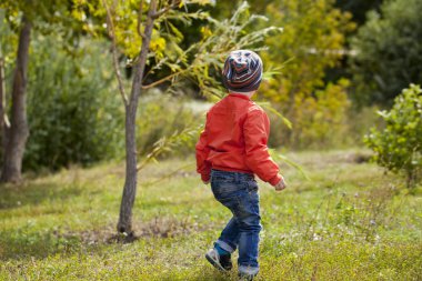Küçük çocuk sonbahar parkta oyun oynarken