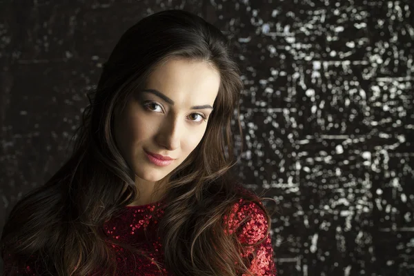 Young brunette woman on dark studio wall background — Stock Photo, Image