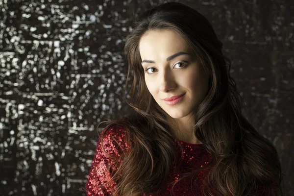 Young brunette woman on dark studio wall background — Stock Photo, Image