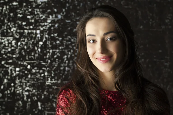 Karanlık stüdyo duvar arka plan üzerinde genç esmer kadın