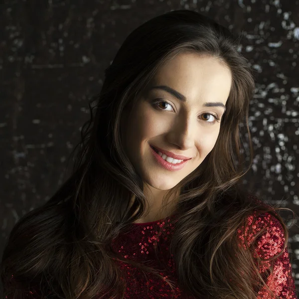 Young brunette woman on dark studio wall background — Stock Photo, Image