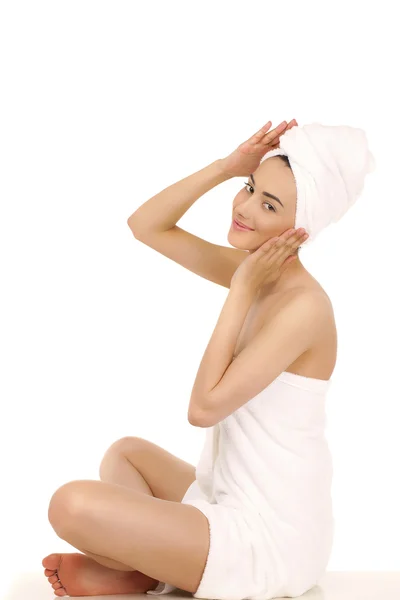Mujer joven envuelta toalla aislada sobre fondo blanco — Foto de Stock