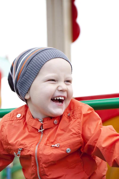 Little boy playing on the playground in the autumn park — Stock Photo, Image