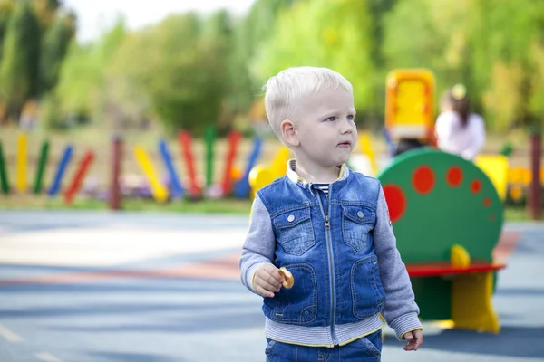 Веселый маленький мальчик бегает по детской площадке — стоковое фото