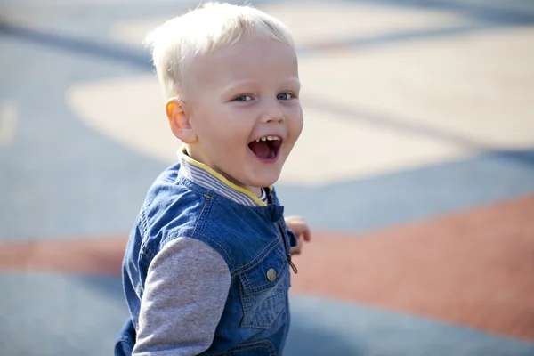 Cheerful little boy running around on the playground — Stock Photo, Image