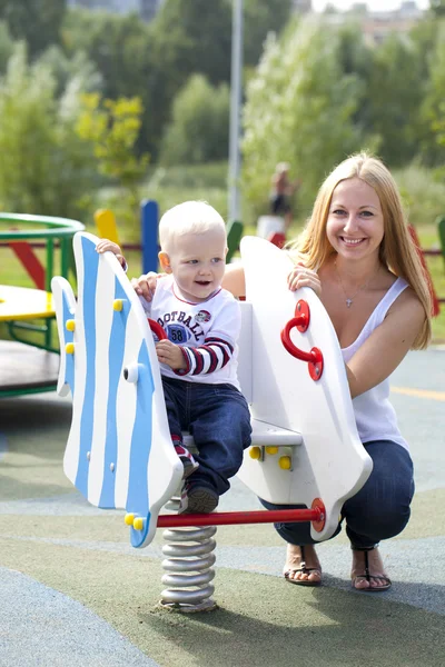 Madre feliz con hijo de dos años en el patio de recreo —  Fotos de Stock