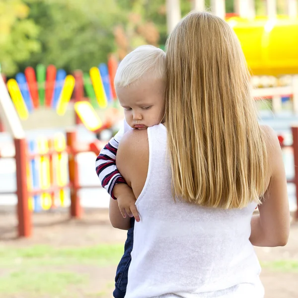 Touchy petit garçon dans les bras de sa mère — Photo