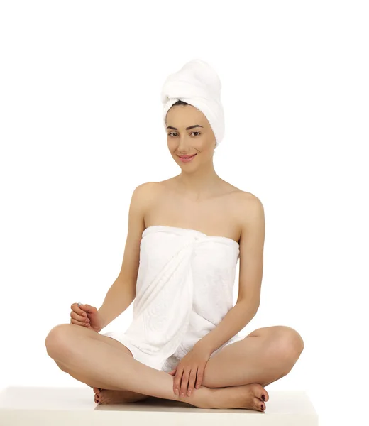 Νεαρή γυναίκα τυλιγμένη πετσέτα που απομονώνονται σε λευκό φόντο — Φωτογραφία Αρχείου
