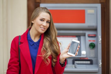 Sarışın kadınla bir telefon backg üzerinde elinde kırmızı paltolu