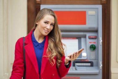 Sarışın kadınla bir telefon backg üzerinde elinde kırmızı paltolu