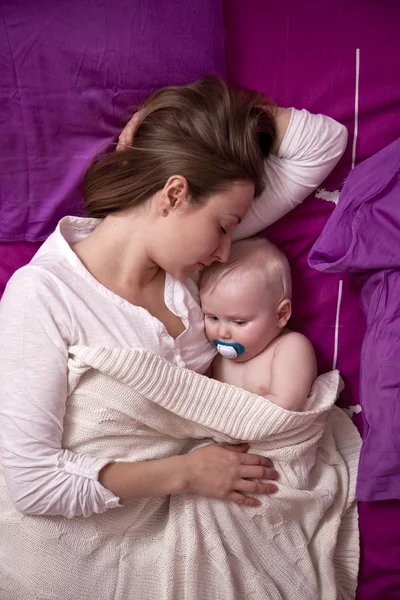 Moeder met haar baby slapen in bed — Stockfoto