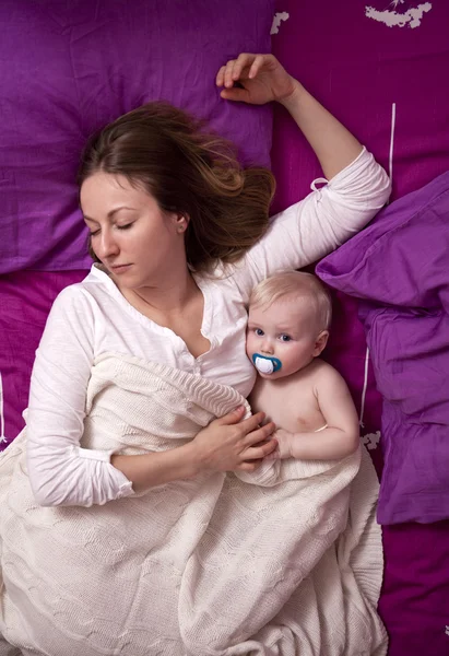 Moeder met haar baby slapen in bed — Stockfoto