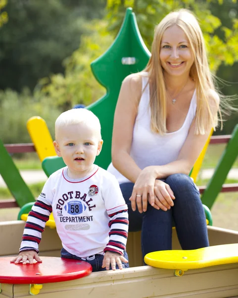 Šťastná matka s dvouletý syn na hřišti — Stock fotografie
