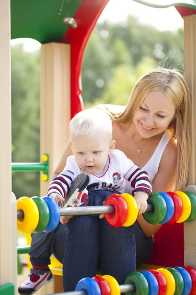 Счастливая мать с двухлетним сыном на детской площадке — стоковое фото