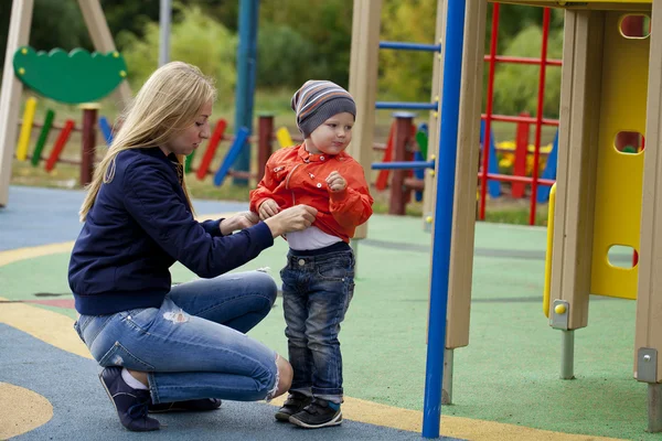 Gelukkig moeder en baby boy spelen op de speelplaats — Stockfoto