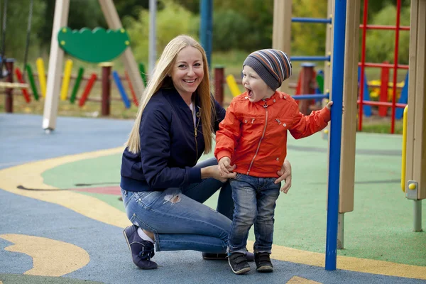 Feliz madre y niño jugando en el patio de recreo —  Fotos de Stock