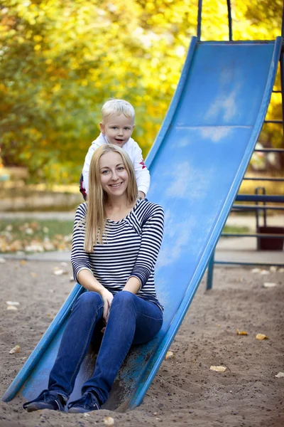 Mãe feliz com filho de dois anos no parque infantil — Fotografia de Stock