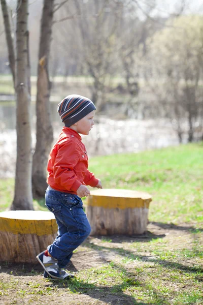 Baby boy in orange jaket and blue jeans — Stock Photo, Image