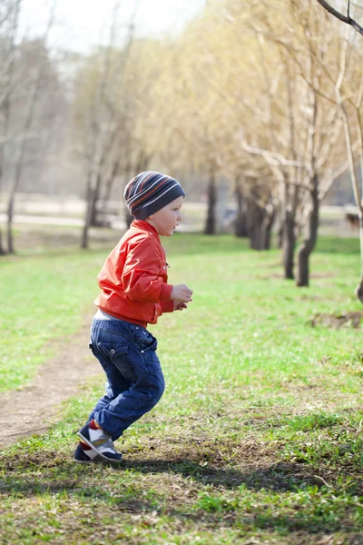 Niño en jaket naranja y jeans azules —  Fotos de Stock