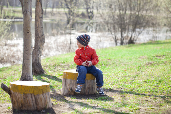 Baby boy in orange jaket and blue jeans