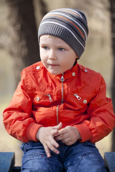 Baby boy in orange jaket and blue jeans — Stock Photo, Image