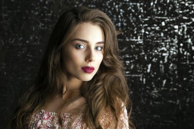 Karanlık stüdyo duvar arka plan üzerinde genç esmer kadın