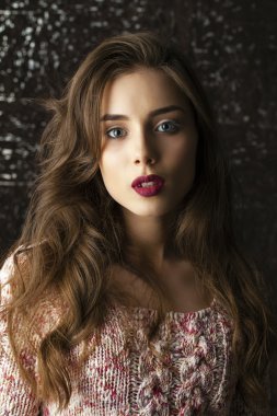 Karanlık stüdyo duvar arka plan üzerinde genç esmer kadın