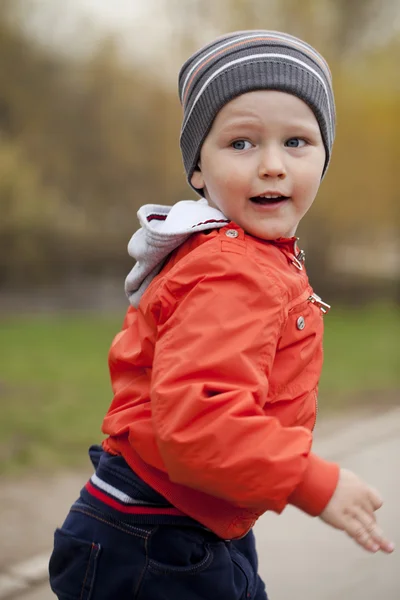 Baby boy in orange jaket and blue jeans — Stock Photo, Image