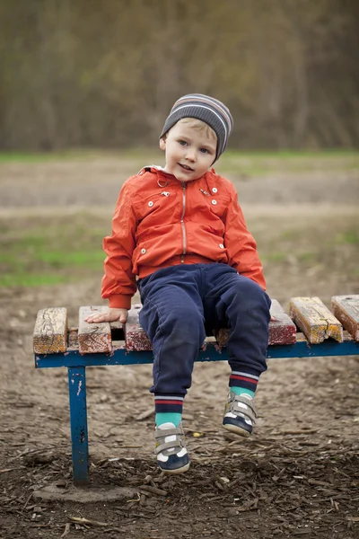 Baby boy in orange jaket and blue jeans — Stock Photo, Image