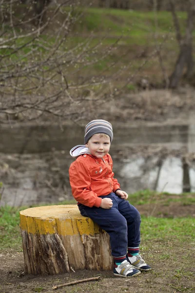 Chłopiec dziecko w jaket pomarańczowy i niebieski jeans — Zdjęcie stockowe