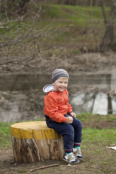 Baby boy in orange jaket and blue jeans — Stock Photo, Image