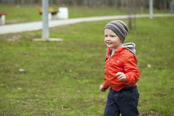 Baby boy in orange jaket and blue jeans — Stock Photo, Image