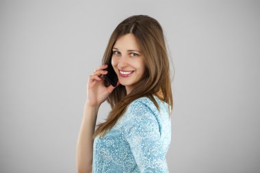 Güzel genç bayan cep telefonuyla konuşuyor.