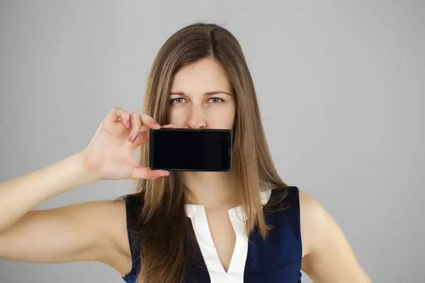 Morena bonita mostrando telefone inteligente — Fotografia de Stock
