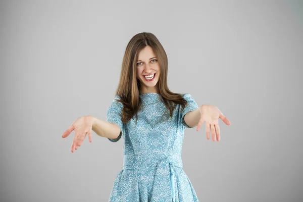 Portret van een mooie jonge vrouw in een turquoise jurk op een gr — Stockfoto