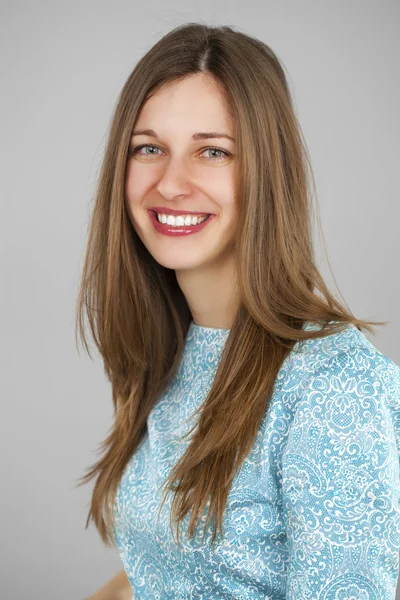 Portrait of a beautiful young woman in a turquoise dress on a gr — Stock Photo, Image