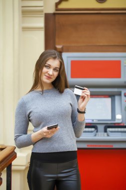 Genç mutlu esmer kadın kredi kartından para çekme