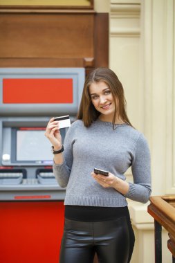 Genç mutlu esmer kadın kredi kartından para çekme