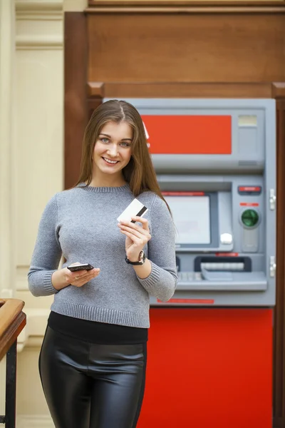 Giovane donna bruna felice ritirare soldi dalla carta di credito a — Foto Stock