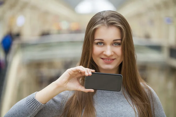 Ung kvinna täcker sitt ansikte skärm smartphone — Stockfoto