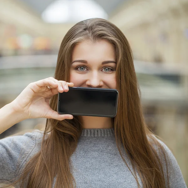 Ung kvinna täcker sitt ansikte skärm smartphone — Stockfoto