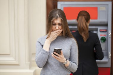 Atm karşı sinir bozucu genç kadın standları 