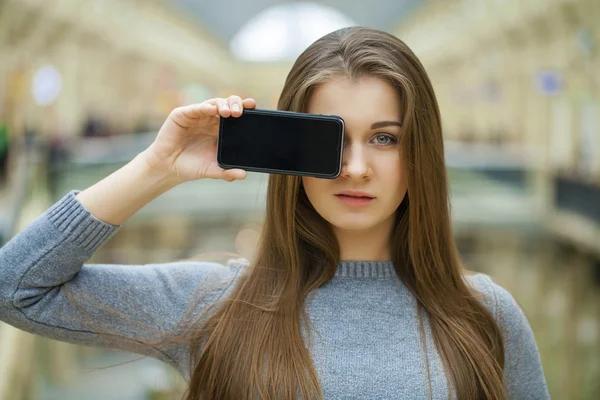 Jeune femme couvre son smartphone écran visage — Photo