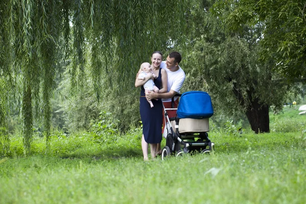 Lyckliga föräldrar med sin unge son i sommaren park — Stockfoto